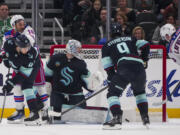 New York Rangers left wing Alexis Lafrenière (13) scores against Seattle Kraken goaltender Philipp Grubauer as center Chandler Stephenson (9), defenseman Ryker Evans (41) and Rangers center Vincent Trocheck (16) look on during the second period of an NHL hockey game Sunday, Nov. 17, 2024, in Seattle.