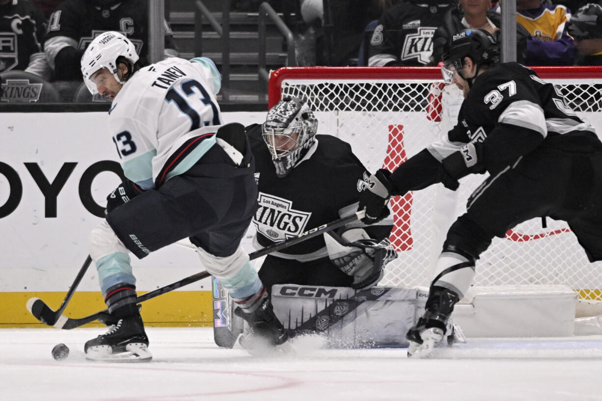 Seattle Kraken left wing Brandon Tanev (13) vies for the puck with Los Angeles Kings goaltender David Rittich (31) and left wing Warren Foegele (37) during the second period of an NHL hockey game in Los Angeles, Saturday, Nov. 23, 2024.