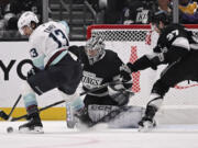 Seattle Kraken left wing Brandon Tanev (13) vies for the puck with Los Angeles Kings goaltender David Rittich (31) and left wing Warren Foegele (37) during the second period of an NHL hockey game in Los Angeles, Saturday, Nov. 23, 2024.