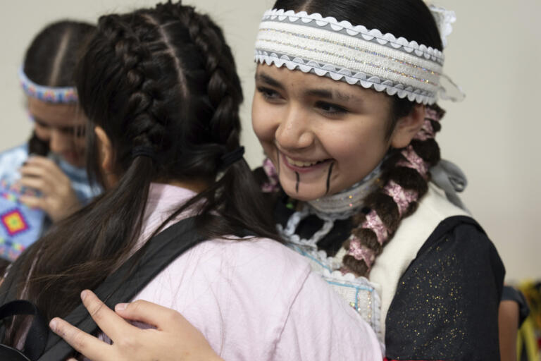 Sun-taa-chu Butler, right, hugs a friend as they get ready for a powwow at Chinook Winds Casino Resort, Saturday, Nov. 16, 2024, in Lincoln City, Ore.