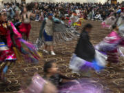 People dance in a powwow at Chinook Winds Casino Resort, Saturday, Nov. 16, 2024, in Lincoln City, Ore.