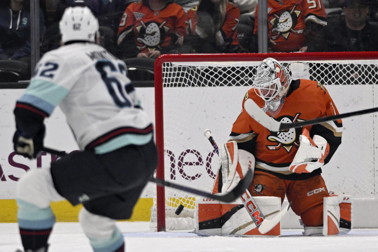 Anaheim Ducks goaltender Lukas Dostal (1) deflects the puck with Seattle Kraken defenseman Brandon Montour (62) watching during the first period of an NHL hockey game in Anaheim, Calif., Monday, Nov. 25, 2024.