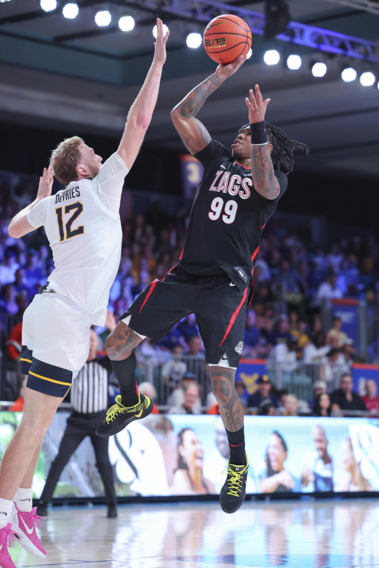 In this handout provided by Bahamas Visual Services, Gonzaga guard Khalif Battle (99)  goes to the basket against West Virginia guard Tucker DeVries (12) during an NCAA college basketball game at the Battle 4 Atlantis tournament in Paradise Island, Bahamas Wednesday, Nov. 27, 2024.