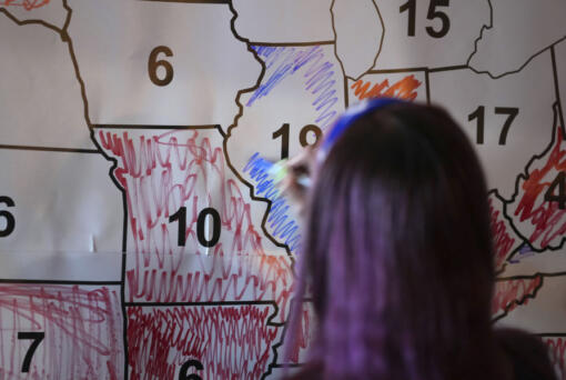 A voter colors the state of Illinois blue during an election night watch party, Tuesday, Nov. 5, 2024, in Cincinnati.