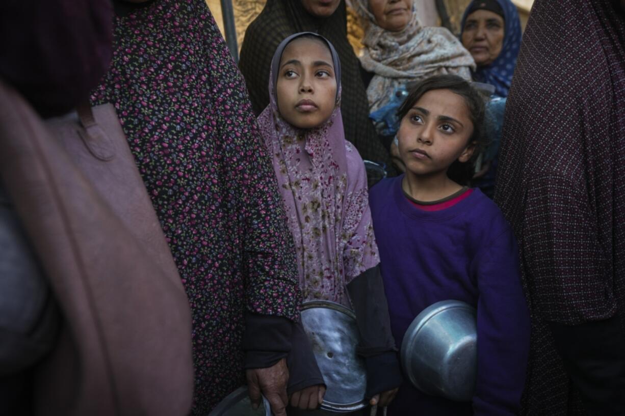 Palestinian children queue at a food distribution kitchen in Deir al-Balah, Gaza Strip, Friday Nov. 22, 2024.