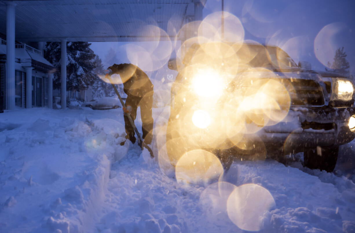 Daniel Sandoval tries to dig out his truck that got stuck in snow after dropping off his daughter at work in Weed, Calif., Wednesday, Nov. 20, 2024.