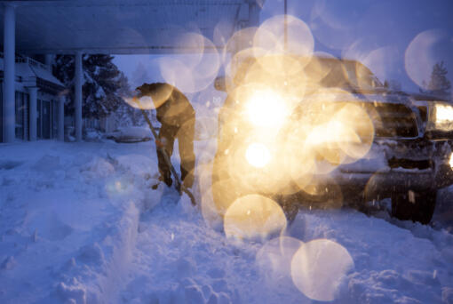 Daniel Sandoval tries to dig out his truck that got stuck in snow after dropping off his daughter at work in Weed, Calif., Wednesday, Nov. 20, 2024.