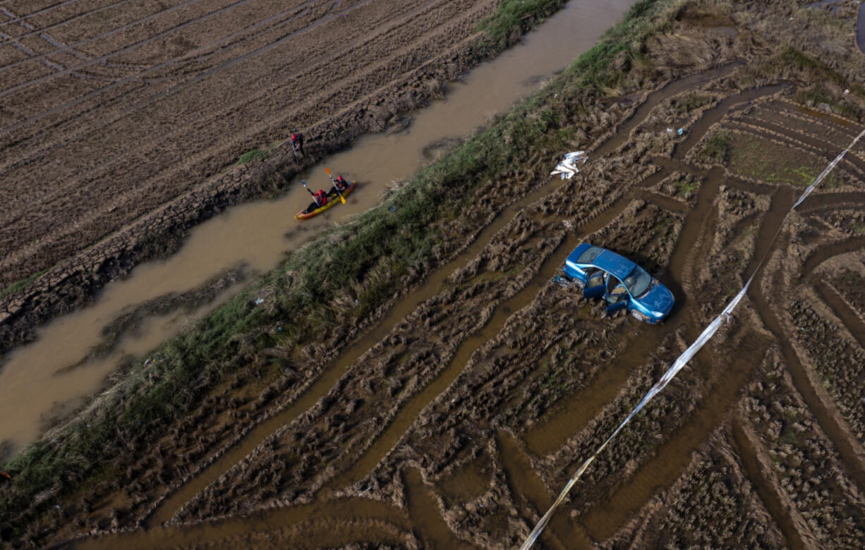 Members of the V battalion of the military emergency unit, UME, use a canoe to search the area for bodies washed away by the floods in the outskirts of Valencia, Spain, Friday, Nov. 8, 2024.