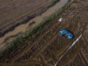 Members of the V battalion of the military emergency unit, UME, use a canoe to search the area for bodies washed away by the floods in the outskirts of Valencia, Spain, Friday, Nov. 8, 2024.