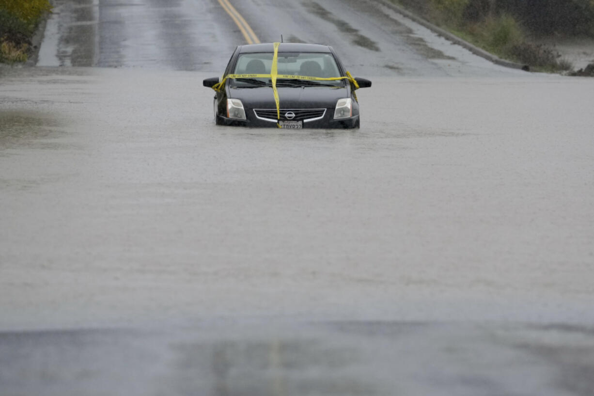 A car is left stranded on a flooded road during a storm Thursday, Nov. 21, 2024, in Windsor, Calif. (AP Photo/Godofredo A.