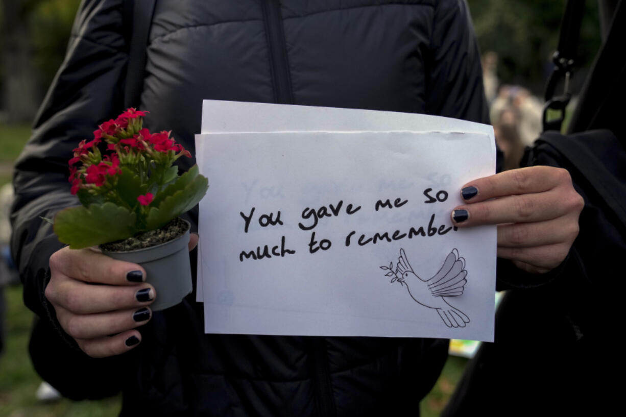 A fan holds a message as fans gather to pay tribute to late British singer Liam Payne, former member of the British pop band One Direction in Treptower Park in Berlin, Germany, Sunday, Oct. 20, 2024.