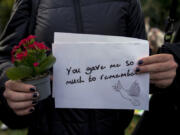 A fan holds a message as fans gather to pay tribute to late British singer Liam Payne, former member of the British pop band One Direction in Treptower Park in Berlin, Germany, Sunday, Oct. 20, 2024.