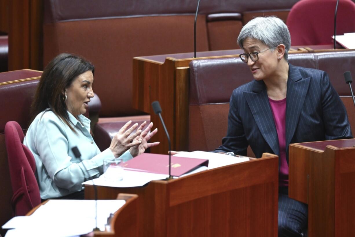 Senator Jacqui Lambie, left, gestures as she speaks to Australian Foreign Minister Penny Wong during debate in the Senate chamber at Parliament House in Canberra, Australia, Thursday, Nov. 28, 2024.