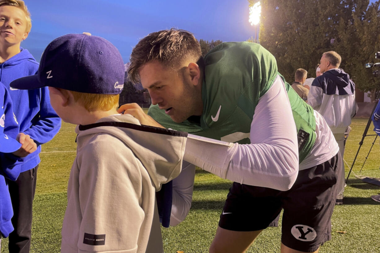 BYU quarterback Jake Retzlaff signs autographs for young fans Nov. 13 after NCAA college football practice in Provo, Utah.