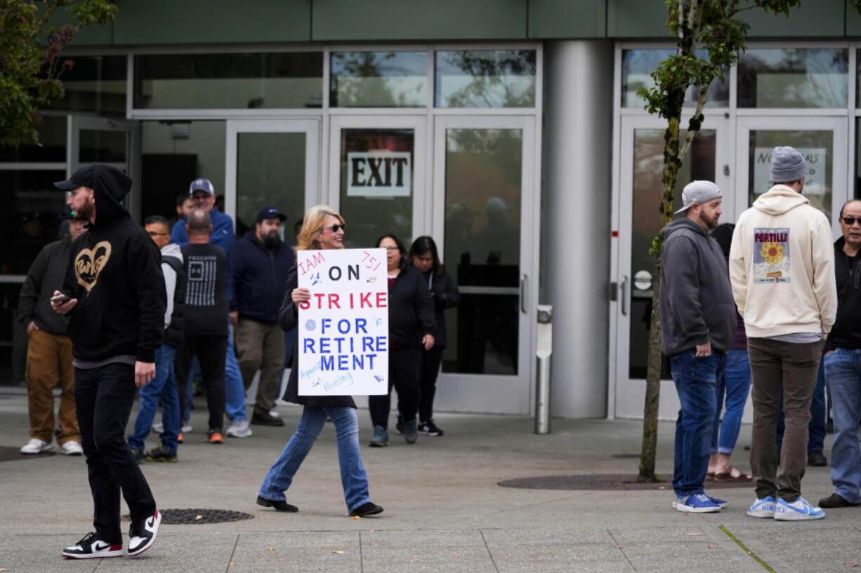 A worker holds a sign as Boeing employees vote on a new contract offer from the company, Wednesday, Oct. 23, 2024, at a voting location in the Angel of the Winds Arena in Everett, Wash.