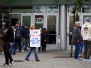 A worker holds a sign as Boeing employees vote on a new contract offer from the company, Wednesday, Oct. 23, 2024, at a voting location in the Angel of the Winds Arena in Everett, Wash.