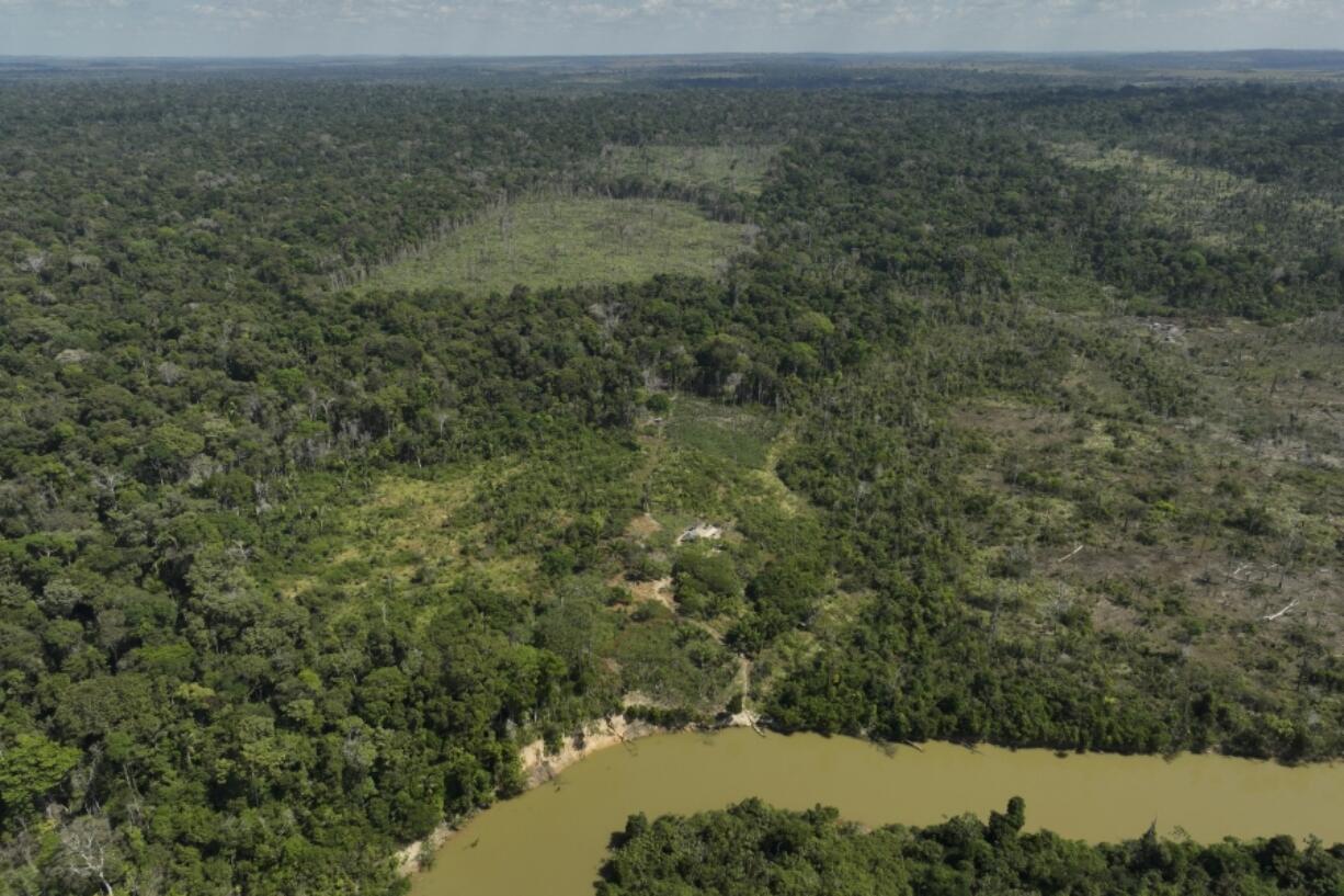 FILE - A river borders an area that has been illegally deforested by land-grabbers and cattle farmers in an extractive reserve in Jaci-Parana, Rondonia state, Brazil, July 11, 2023.