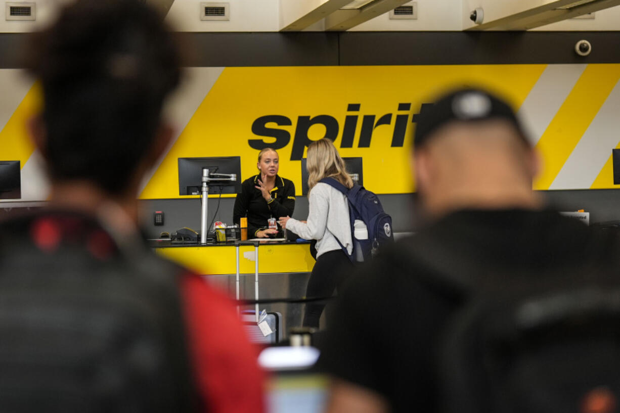 FILE - A traveler speaks with a Spirit Airlines agent at Hartsfield-Jackson Atlanta International Airport ahead of Memorial Day, on May 24, 2024, in Atlanta.