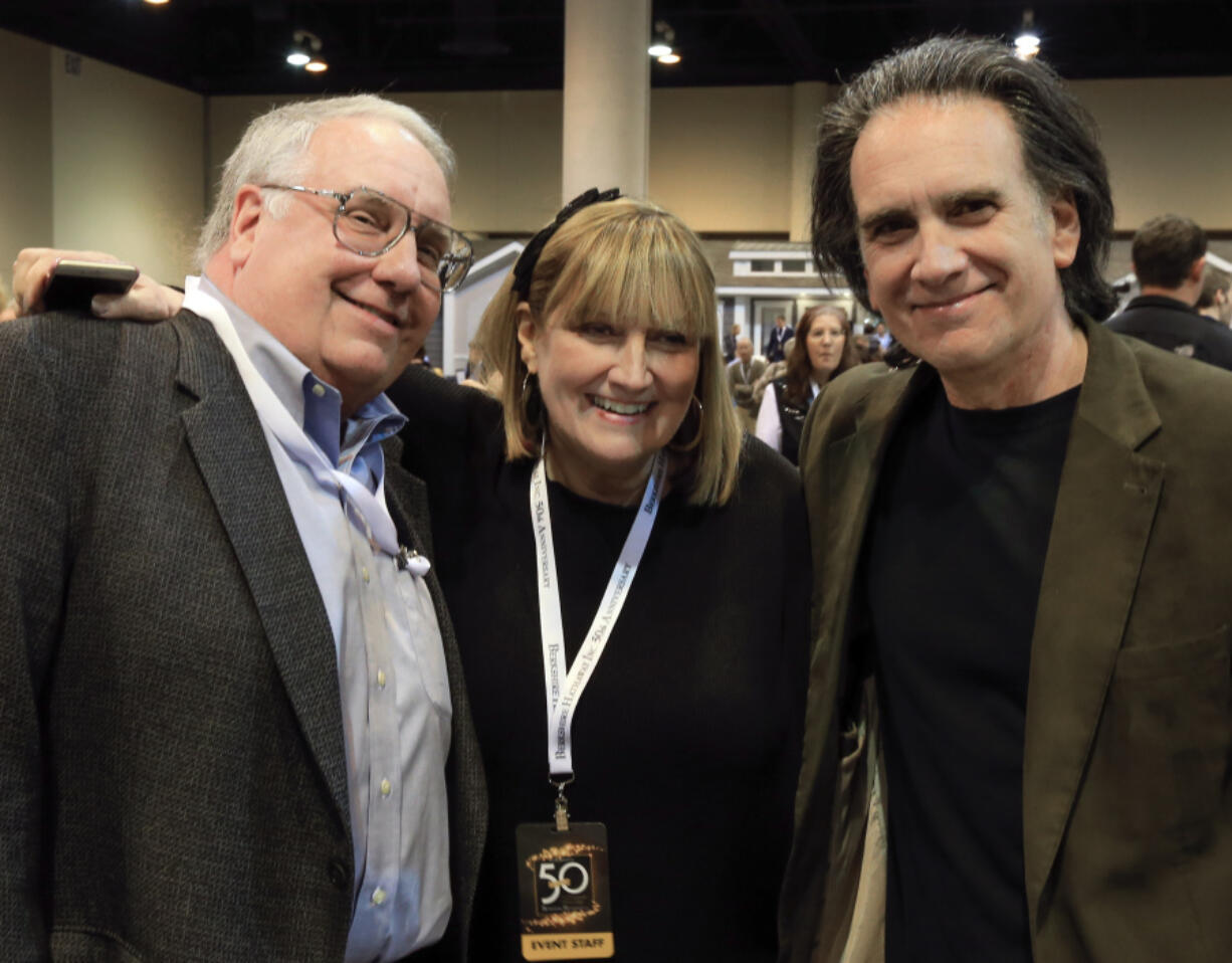 The children of Berkshire Hathaway Chairman and CEO Warren Buffett, from left, Howard Buffett, Susie Buffett, and Peter Buffett, pose for a photo at the CenturyLink Center exhibit hall in Omaha, Neb., May 1, 2015.