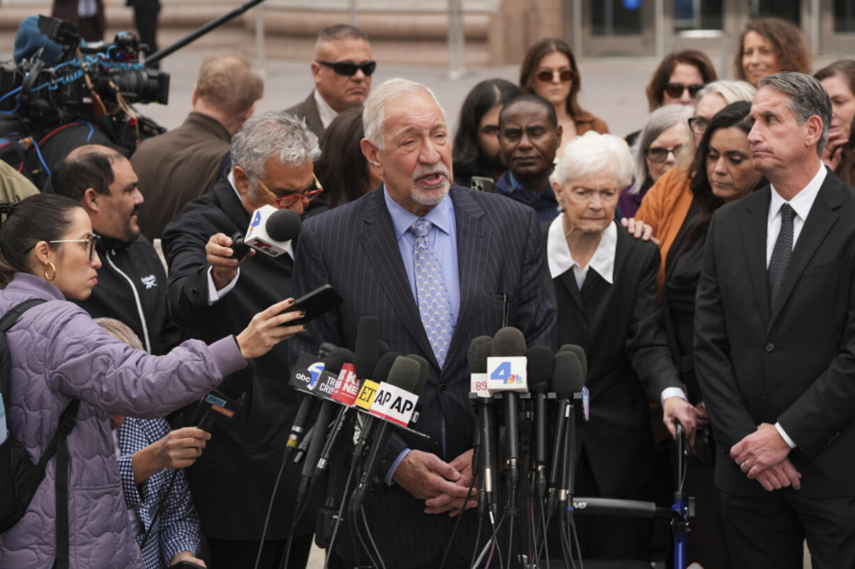 Joined by family members of Erik and Lyle Menendez, attorney Mark Geragos, center, speaks during a news conference after a hearing in Los Angeles, Monday, Nov. 25, 2024. (AP Photo/Jae C.