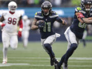 Seattle Seahawks wide receiver Jaxon Smith-Njigba (11) runs the ball for 46 yards, setting up a touchdown, during the first half of an NFL football game against the Arizona Cardinals, Sunday, Nov. 24, 2024, in Seattle.