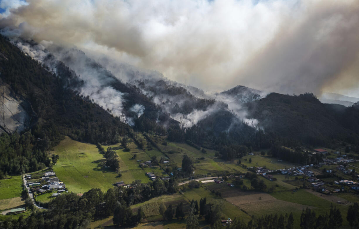 FILE - Smoke rises from a fire burning on the slopes of the mountains surrounding Nemocon, north of Bogota, Colombia, Jan. 23, 2024.