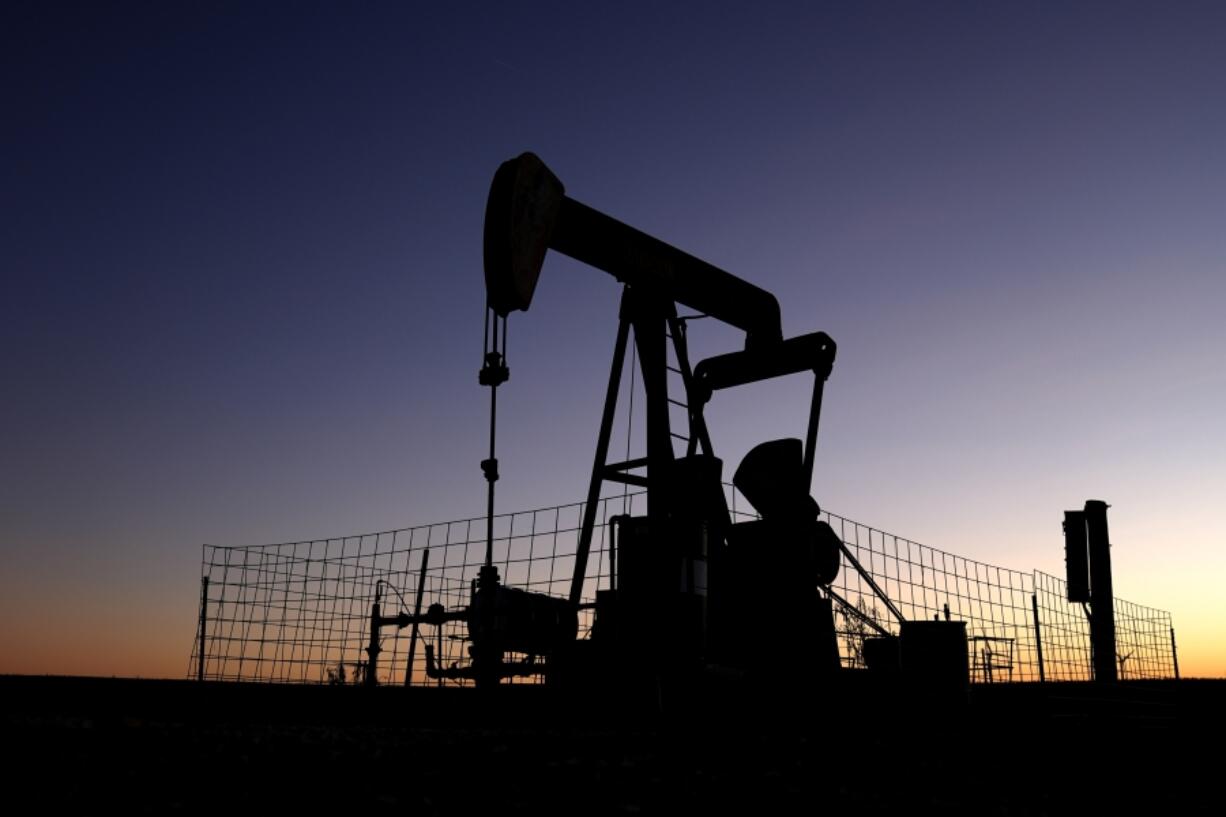 A pumpjack operates at dawn in a pasture, Monday, Sept. 30, 2024, near Hays, Kan.