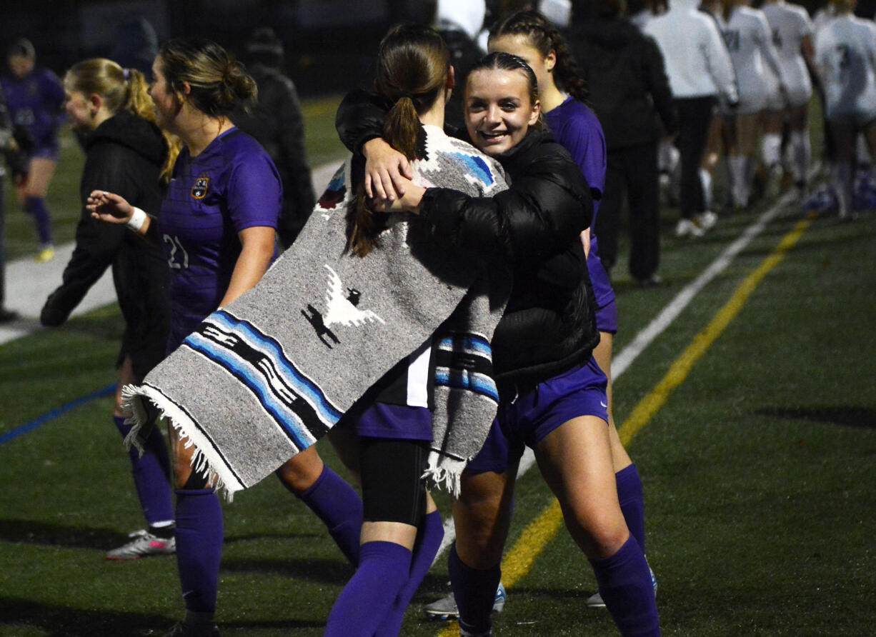 Ivy Henderson (right) of Columbia River hugs teammate Peyton Dukes after the Rapids' 4-0 win over Ellensburg in a Class 2A girls soccer state quarterfinal match at Columbia River High School on Saturday, Nov. 16, 2024.