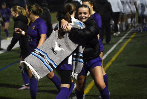 Ivy Henderson (right) of Columbia River hugs teammate Peyton Dukes after the Rapids' 4-0 win over Ellensburg in a Class 2A girls soccer state quarterfinal match at Columbia River High School on Saturday, Nov. 16, 2024.