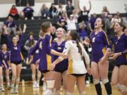 Columbia River players embrace teammate Sydney Dreves (4) after the Rapids won the second set in the Class 2A District 4 volleyball championship against Ridgefield on Saturday, Nov. 9, 2024, at Woodland High School.