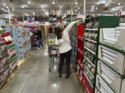 FILE - Shoppers reach for items on display in a Costco warehouse Nov. 19, 2024, in Lone Tree, Colo.