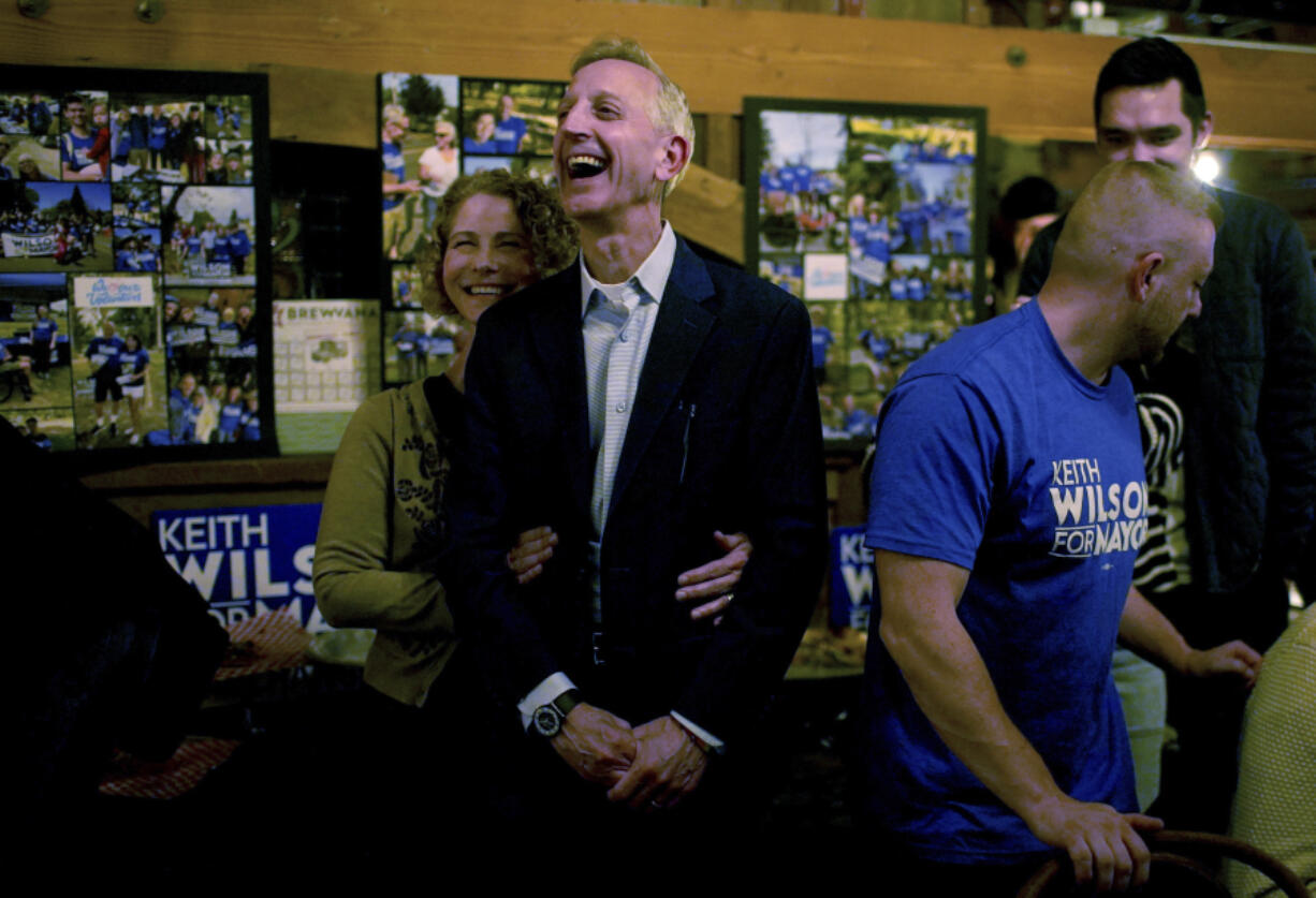 Portland mayoral candidate Keith Wilson with his wife, Katherine, watch local news election returns on a large screen at Old Town Brewing in Portland, Ore., Tuesday, Nov. 5, 2024.