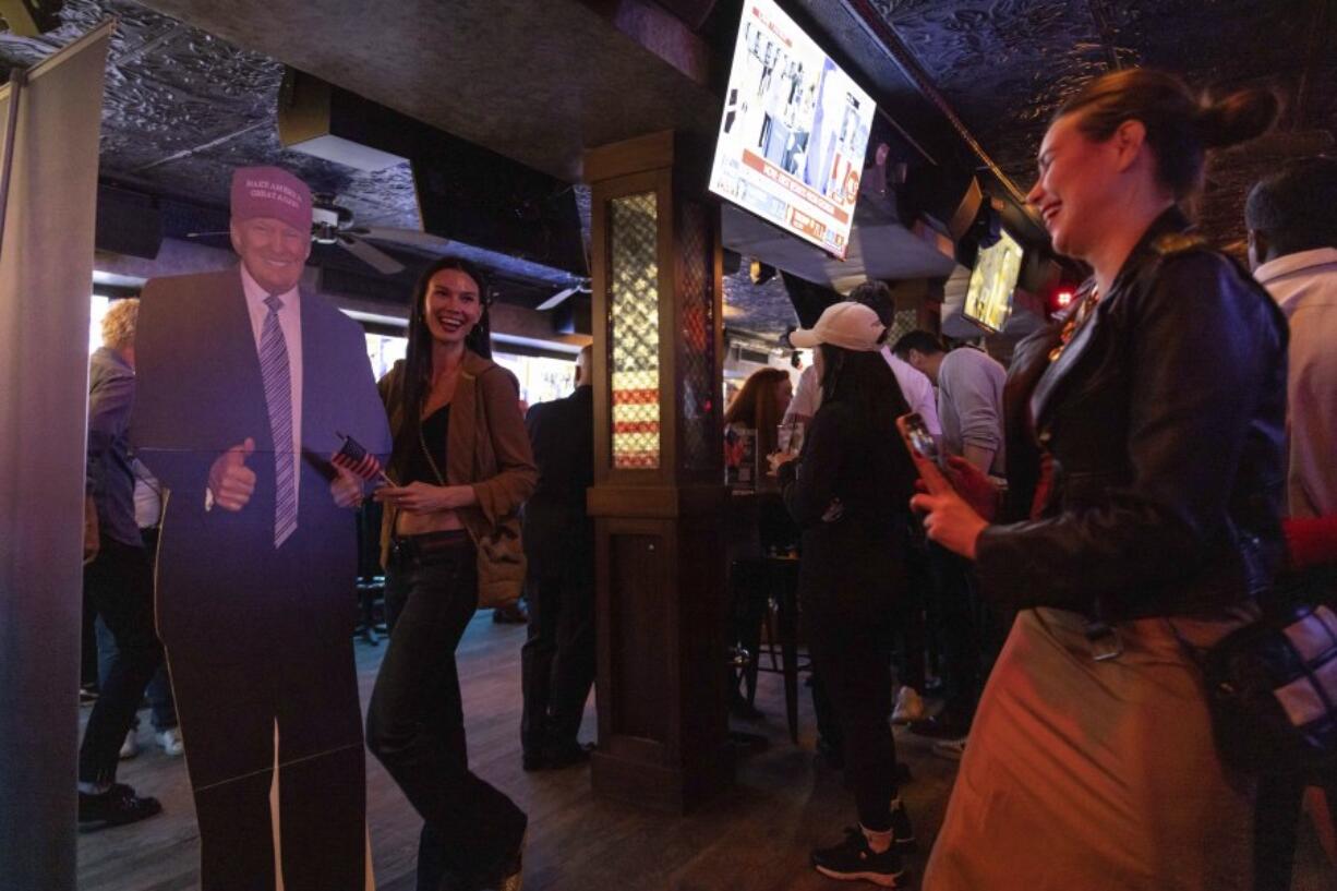 People takes pictures with a cutout of Republican presidential nominee former President Donald Trump at a watch party hosted by the New York Young Republican Club in New York on Election Day, Tuesday, Nov. 5, 2024.