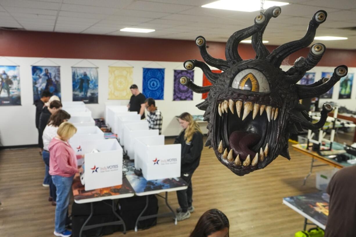 Beholder, a fictional monster in the Dungeons &amp; Dragons fantasy role-playing game, hangs over a voting site as voter cast their ballots on Election Day, at The Game Preserve store in Indianapolis, Tuesday, Nov. 5, 2024.