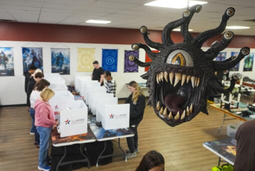 Beholder, a fictional monster in the Dungeons &amp; Dragons fantasy role-playing game, hangs over a voting site as voter cast their ballots on Election Day, at The Game Preserve store in Indianapolis, Tuesday, Nov. 5, 2024.