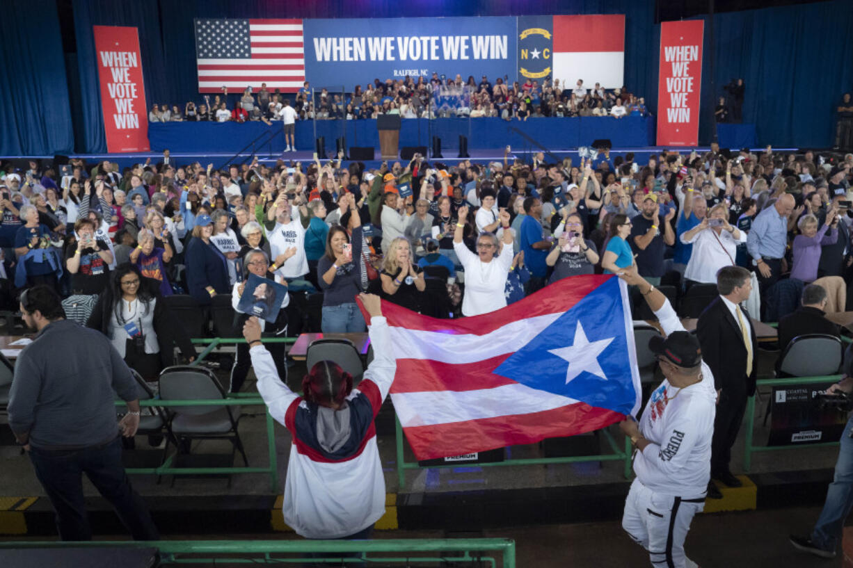 Supporters carry the Puerto Rican flag before Democratic presidential nominee Vice President Kamala Harris arrives to speak at a campaign rally, Wednesday, Oct. 30, 2024, in Raleigh, N.C.