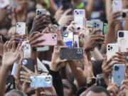 Supporters of Vice President Kamala Harris hold up their phones as she delivers a concession speech for the 2024 presidential election, Wednesday, Nov. 6, 2024, on the campus of Howard University in Washington.