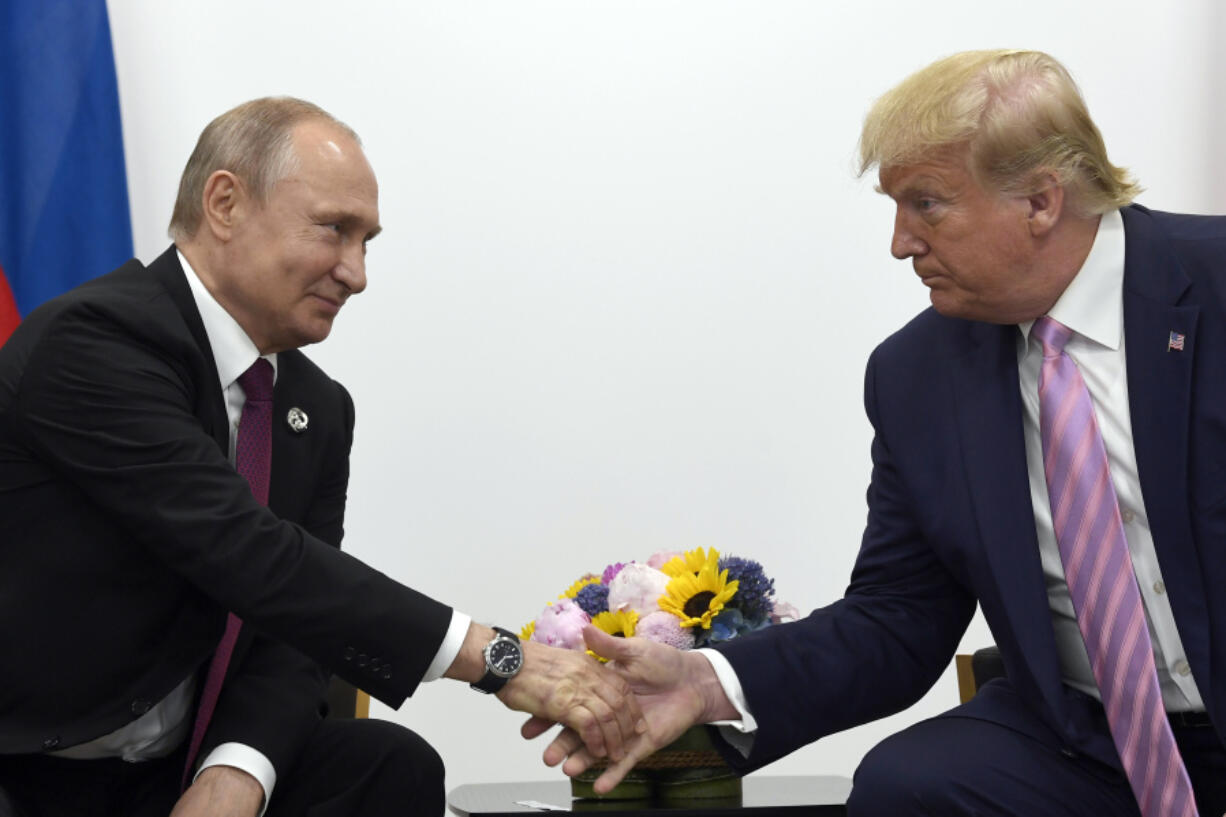 FILE - In this June 28, 2019, file photo, President Donald Trump, right, shakes hands with Russian President Vladimir Putin, left, during a bilateral meeting on the sidelines of the G-20 summit in Osaka, Japan.