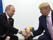 FILE - In this June 28, 2019, file photo, President Donald Trump, right, shakes hands with Russian President Vladimir Putin, left, during a bilateral meeting on the sidelines of the G-20 summit in Osaka, Japan.