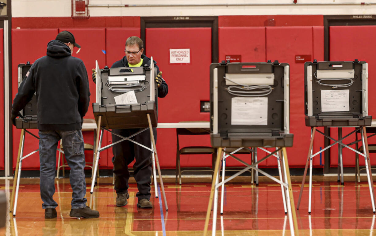 North Attleboro, Mass. highway department employees move voting booths into position at the town high school, Monday, Nov. 4 2024, in preparation for Election Day on Tuesday.