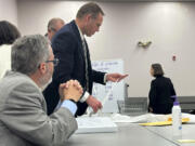 Attorneys and observers review a printout from a voting machine to ensure the numbers match with the reported results as the state of Maine conducts additional tabulations under ranked choice voting in a congressional race Nov. 12 in Augusta.