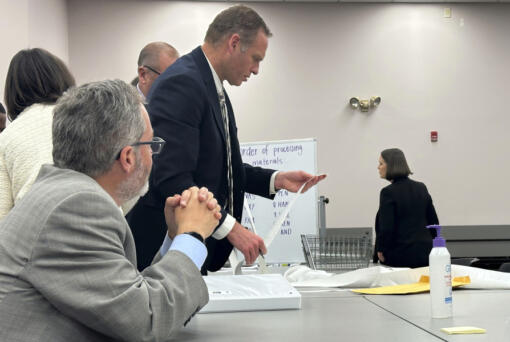 Attorneys and observers review a printout from a voting machine to ensure the numbers match with the reported results as the state of Maine conducts additional tabulations under ranked choice voting in a congressional race Nov. 12 in Augusta.