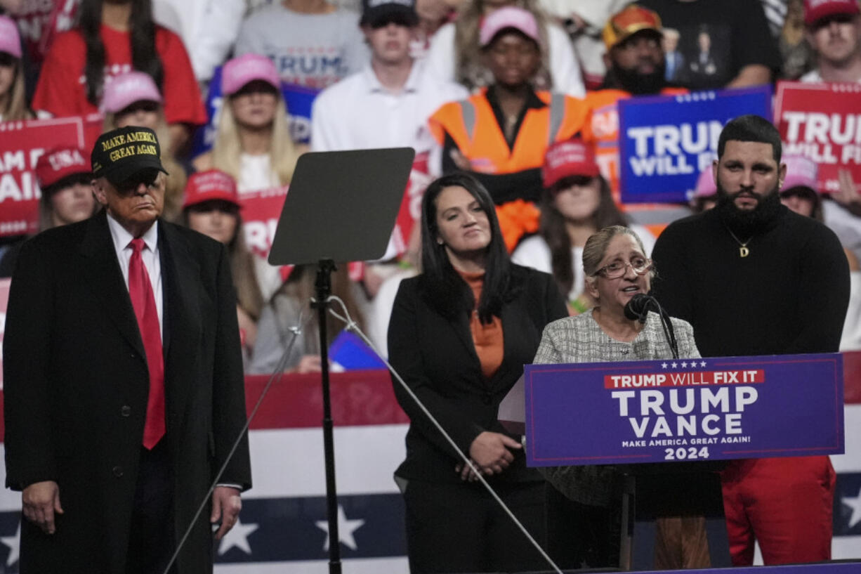 Carmen Ramirez, mother of Minelys &ldquo;Mimi&rdquo; Rodriguez Ramirez speaks as Republican presidential nominee former President Donald Trump, left, listens during a campaign rally at Atrium Health Amphitheater, Sunday, Nov. 3, 2024, in Macon, Ga.