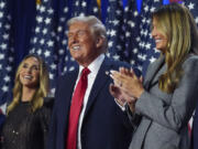 Republican presidential nominee former President Donald Trump stands on stage with former first lady Melania Trump, as Lara Trump watches, at an election night watch party at the Palm Beach Convention Center, Wednesday, Nov. 6, 2024, in West Palm Beach, Fla.