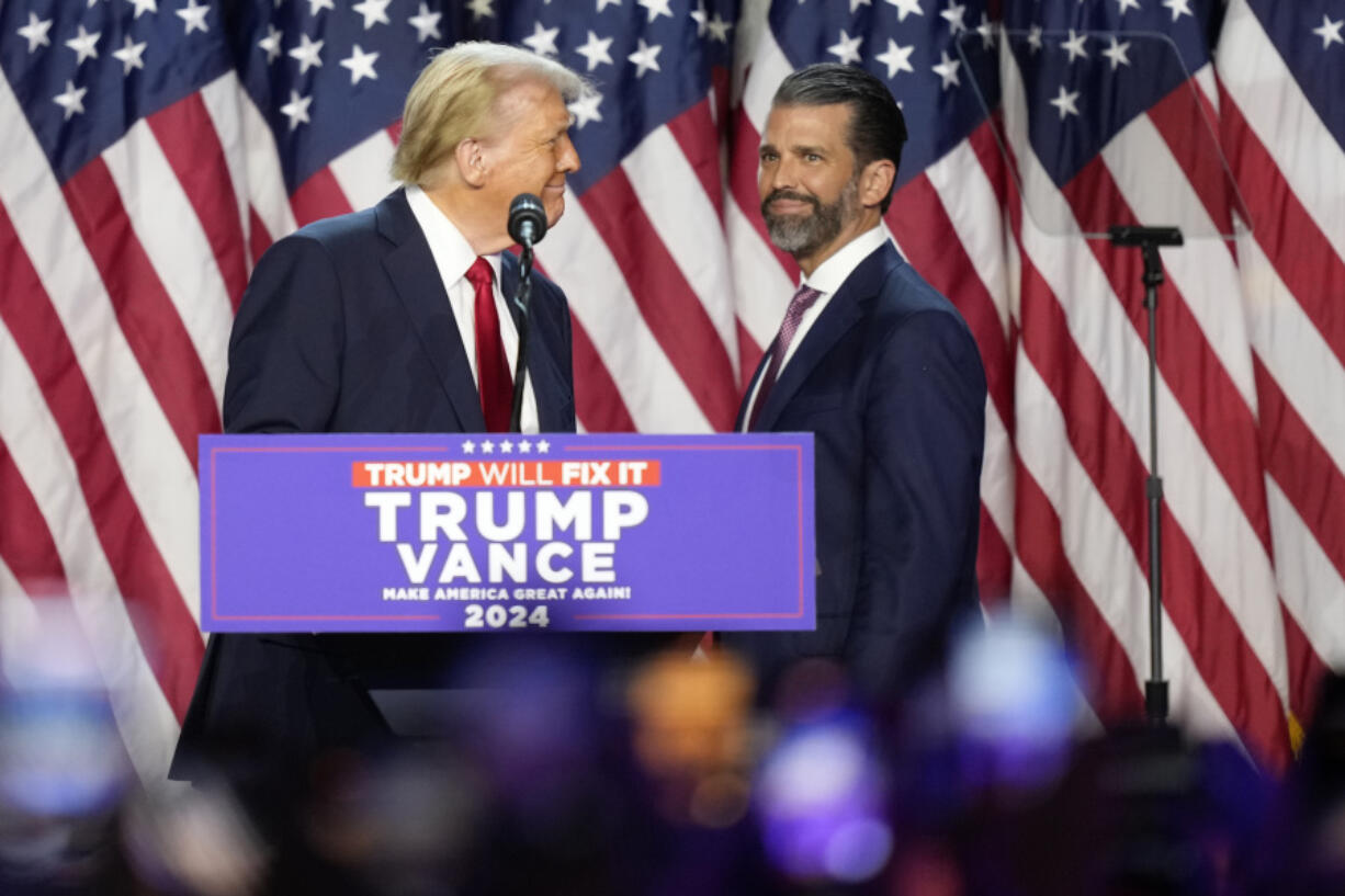 Republican presidential nominee former President Donald Trump, left, looks at his son Donald Trump Jr. at an election night watch party, Wednesday, Nov. 6, 2024, in West Palm Beach, Fla.