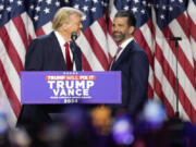 Republican presidential nominee former President Donald Trump, left, looks at his son Donald Trump Jr. at an election night watch party, Wednesday, Nov. 6, 2024, in West Palm Beach, Fla.