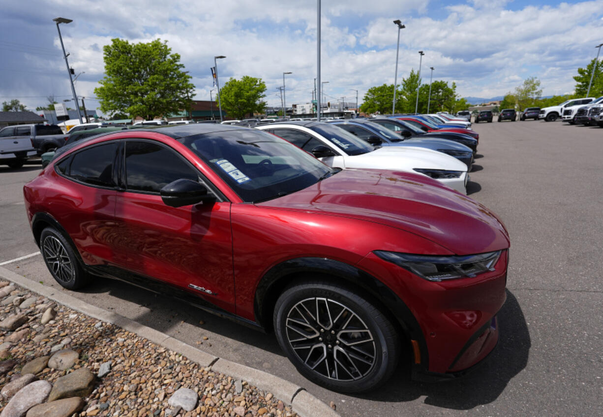 FILE - A line of unsold 2024 Mustang Mach-E electric utility vehicles sit at a Ford dealership May 19, 2024, in Denver.