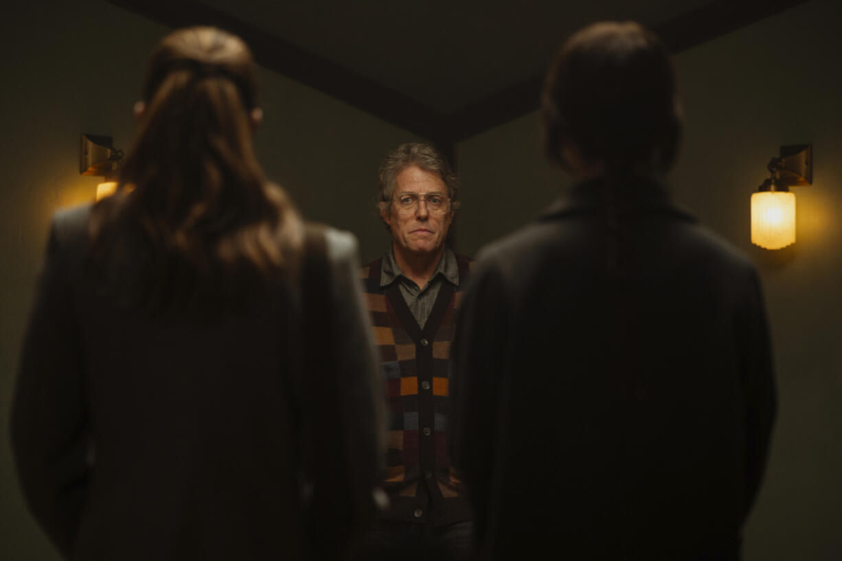 This image released by A24 shows, from left, Chloe East, Hugh Grant, and Sophie Thatcher in a scene from &ldquo;Heretic.&rdquo; (Kimberley French/A24 via AP)