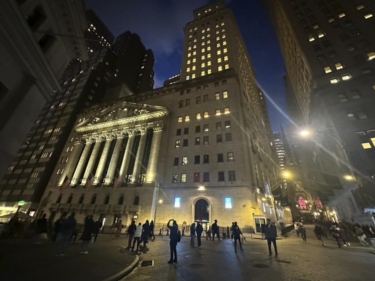 FILE - People walk past the New York Stock Exchange on Tuesday, Nov. 26 2024.