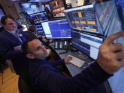 A pair of traders work in their booth on the floor of the New York Stock Exchange, Thursday, Nov. 7, 2024.